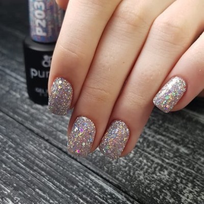 Unhas com verniz de gel glitter prateado em fundo de madeira cinzenta