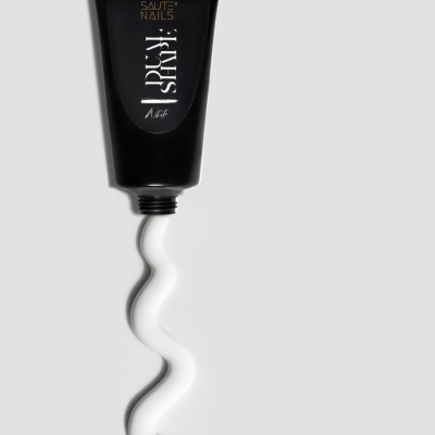 Tubo preto de produto SAUTE NAILS com líquido branco formando ziguezague