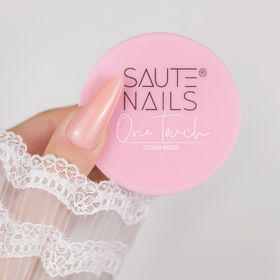 Frasco rosa do produto para unhas 'SAUTE NAILS One Touch COVER NUDE' com mão com unha nude e renda branca
