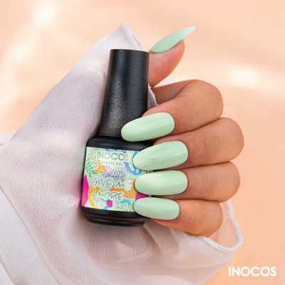 Mão com unhas verdes segurar verniz gel INOCOS