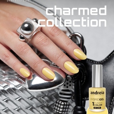 Unhas pintadas de amarelo claro com verniz gel da marca Andreia e anel prateado