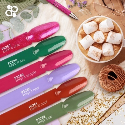 Amostras de verniz para unhas coloridas com texto, chá com marshmallows ao lado, caneta rosa e decoração