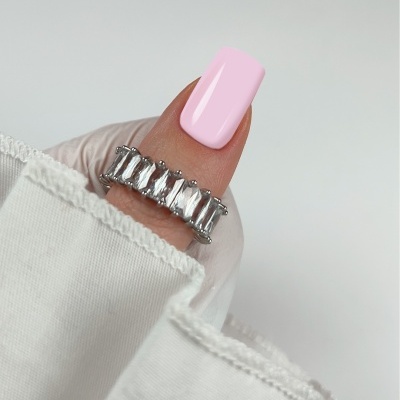 Anel de prata com pedras retangulares numa mão com unha rosa e manga branca