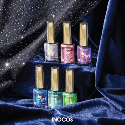 Seis frascos de verniz de unhas coloridos com tampas douradas sobre tecido azul escuro brilhante