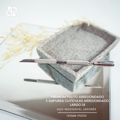 Palito empurra cutículas em aço inoxidável japonês sobre tabuleiro cinza e ramo seco