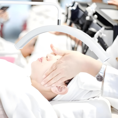 Pessoa recebendo massagem facial com dispositivo de luz curva suspenso