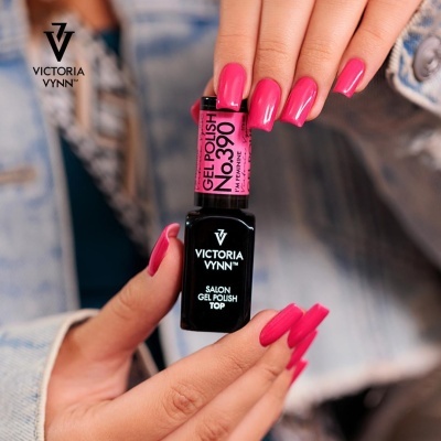 Unhas rosa segurando frascos de verniz gel Victoria Vynn com roupa jeans ao fundo