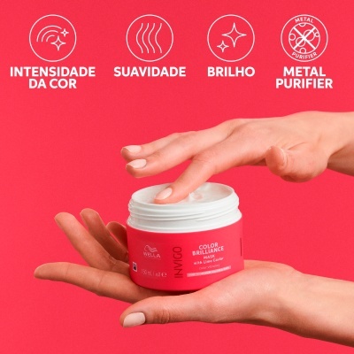 Frasco vermelho de creme para cabelo Wella INVIGO COLOR BRILLIANCE em mãos femininas sobre fundo vermelho.