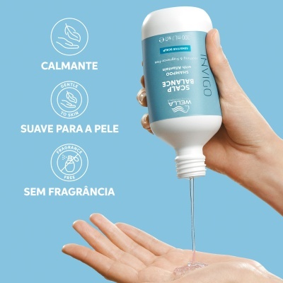 Mão a verter shampoo Wella Invigo Scalp Balance do frasco para a mão, sobre fundo azul claro.