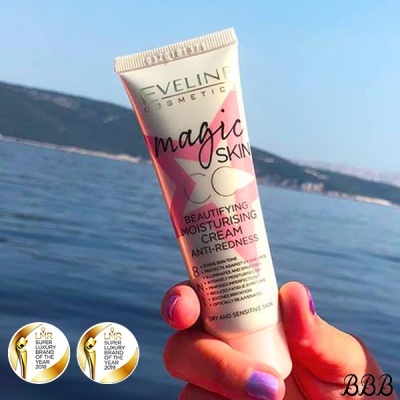 Tubo de creme Eveline Magic Skin segurado com fundo de mar e montanhas
