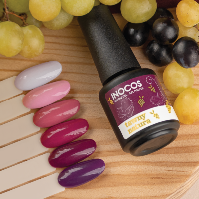 Verniz gel INOCOS Tawny Natura com amostras de cores e uvas sobre madeira.