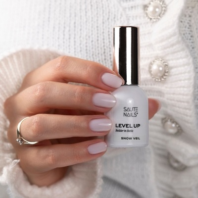 Frasco branco de verniz para unhas SAUTE NAILS LEVEL UP com mão feminina e suéter branco