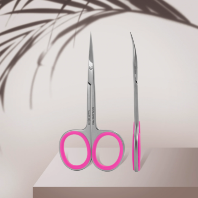 Duas tesouras pequenas em aço inoxidável com cabos rosa sobre superfície branca e sombra de planta.