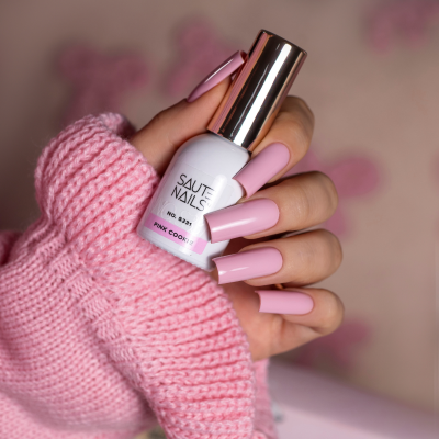 Unhas longas pintadas de rosa segurando verniz branco PINK COOKIE.