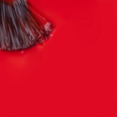 Pincel aplicando verniz vermelho brilhante
