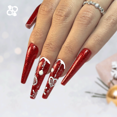 Unhas artificiais vermelhas com glitter e decoração branca e dourada em mão feminina com anel prateado