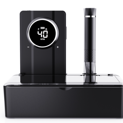 Dispositivo eletrônico preto com ecrã digital e peça cilíndrica vertical numa base retangular