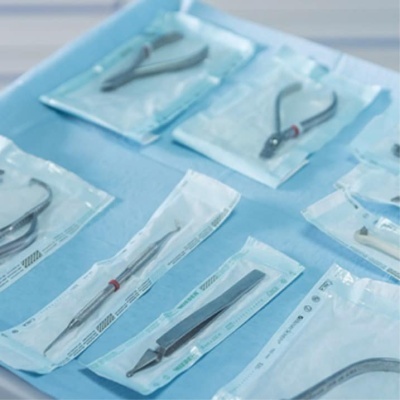 Instrumentos cirúrgicos embalados em plástico transparentes sobre base azul