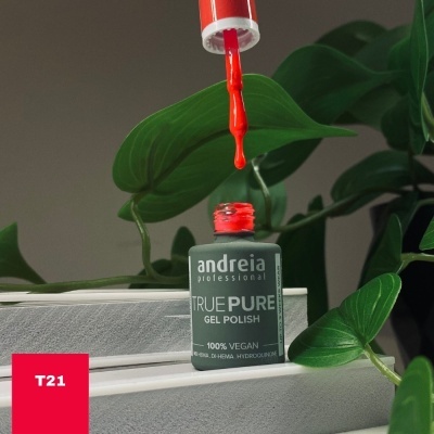 Verniz gel vermelho da marca andreia professional com pincel e planta verde ao fundo