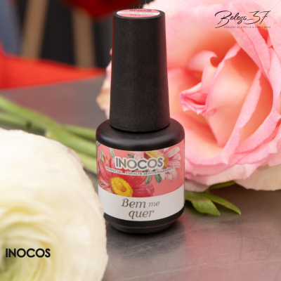 Frasco de verniz de unhas INOCOS 'Bem me quer' com flores ao fundo