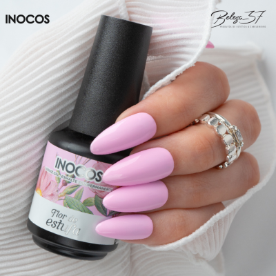 Verniz gel INOCOS Flor da Estufa em mão com unhas rosa pastel e anéis prateados