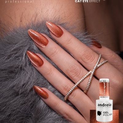 Unhas com verniz gel brilhante laranja e anel dourado com strass sobre fundo cinzento peludo