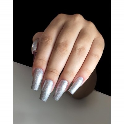 Mão com unhas pintadas de verniz prateado glitter