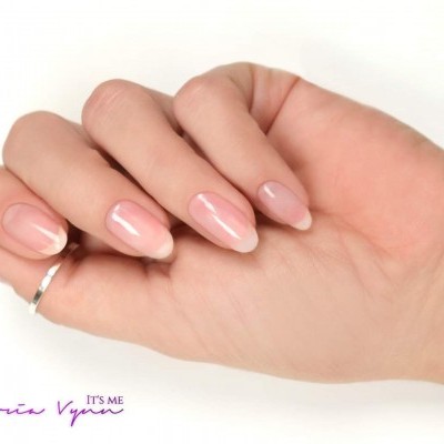 Mão feminina com unhas rosadas e anel prateado