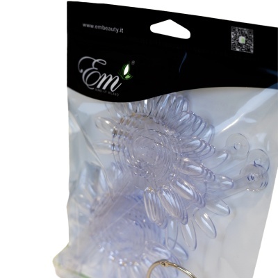 Embalagem plástica transparente contendo produto em forma de flores e embalagem preta com texto www.embeauty.it e logótipo Em