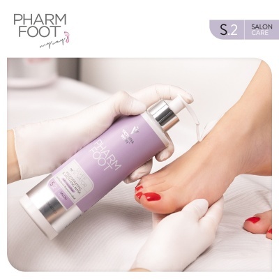 Frasco lilás PHARM FOOT S.2 sendo aplicado num pé com unhas vermelhas