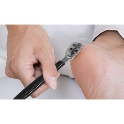 Ferramenta metálica com cabo preto usada para remover pele morta do calcanhar