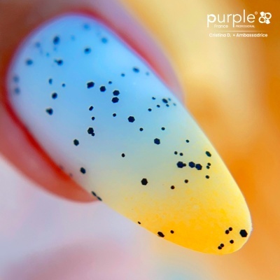 Unha artificial com padrão degradê azul e amarelo e manchas pretas, texto 'purple France PROFESSIONAL' visível.