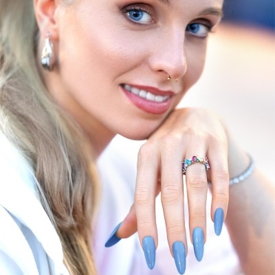 Mulher com unhas azuis em gel e joias