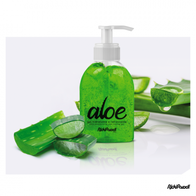 Frasco de gel hidratante e refrescante verde com tampa de bomba branco e folhas de aloe vera frescas ao redor