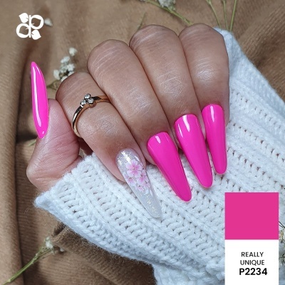 Mão com unhas artificiais em rosa fluorescente e padrão floral