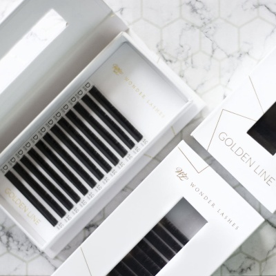 Caixa branca de pestanas postiços Golden Line Wonder Lashes sobre superfície de mármore