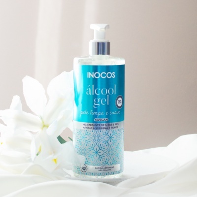 Frasco de álcool gel Inocos com rótulo azul e branco, embalagem transparente e doseador branco