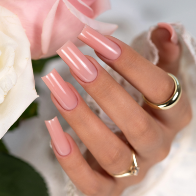 Mãos femininas com unhas longas rosa claro segurando rosas cor-de-rosa e brancas
