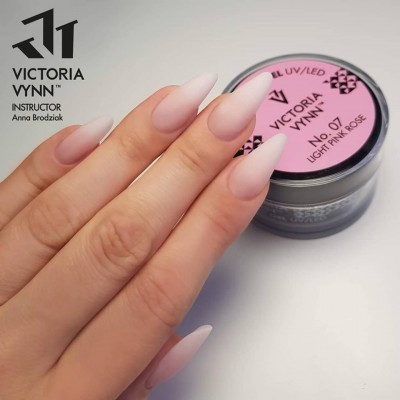 Unhas compridas rosa claro com pote de gel UV/LED Victoria Vynn no fundo
