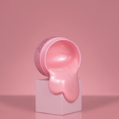 Frasco de gel rosa brilhante para unhas derramando sobre cubo rosa claro