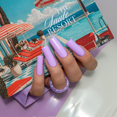 Unhas postiças lilás segurando catálogo com tema resort e piscina