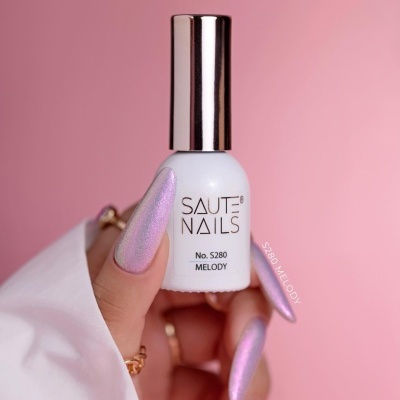 Frasco de verniz de unhas branco com tampa prateada segurado por mão com unhas rosa cintilante