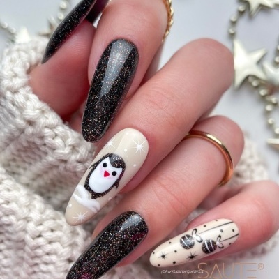 Unhas decoradas com verniz preto brilhante e desenhos de pinguim e abelhas em creme.