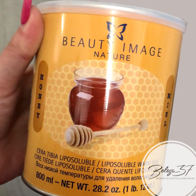 Frasco amarelo de cera lipossolúvel com imagem de pote de mel e colher de mel