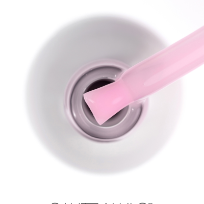 Frasco aberto de verniz para unhas rosa claro com escova e texto SAUTE NAILS®