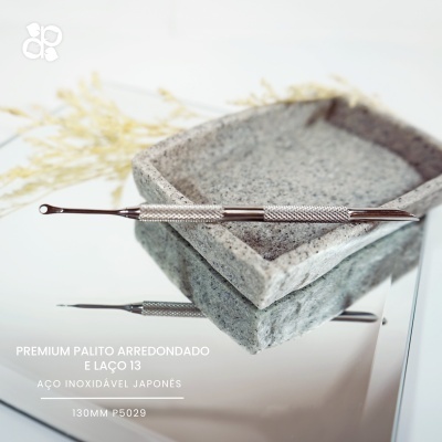 Instrumento metálico de aço inoxidável sobre recipiente de pedra cinza