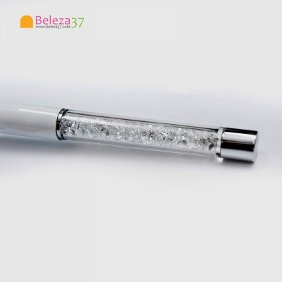 Detalhe de objeto cilíndrico com cristais brilhantes e extremidade metálica