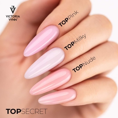 Unhas longas pintadas em três tons de verniz cor-de-rosa suave com texto Victoria Vynn