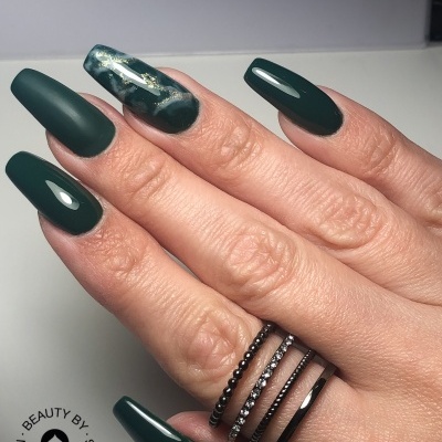 Mão feminina com unhas longas verdes e anéis finos preto e prata