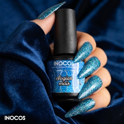 Frasco de verniz de unhas INOCOS 'elogiar mais' com unhas azuis cintilantes